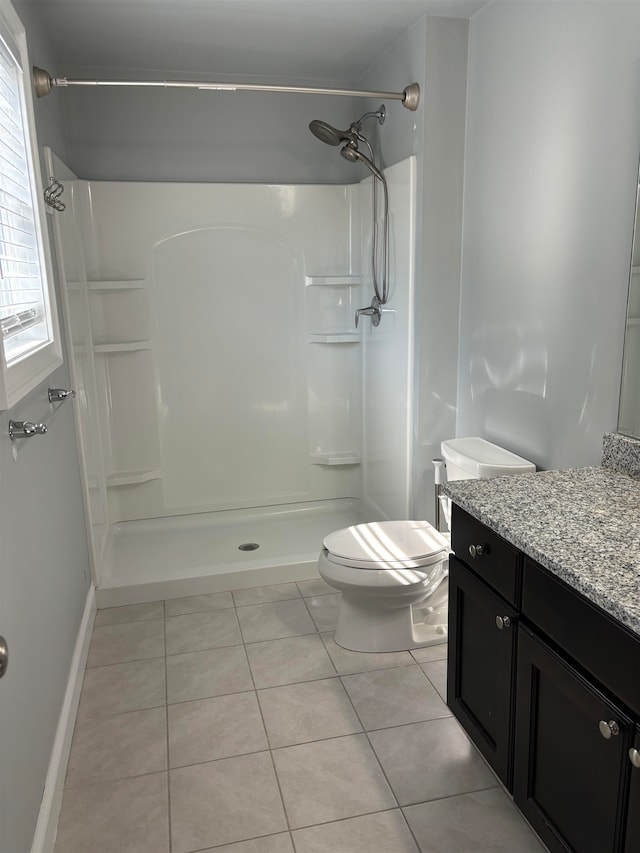 bathroom featuring tile patterned floors, vanity, toilet, and walk in shower