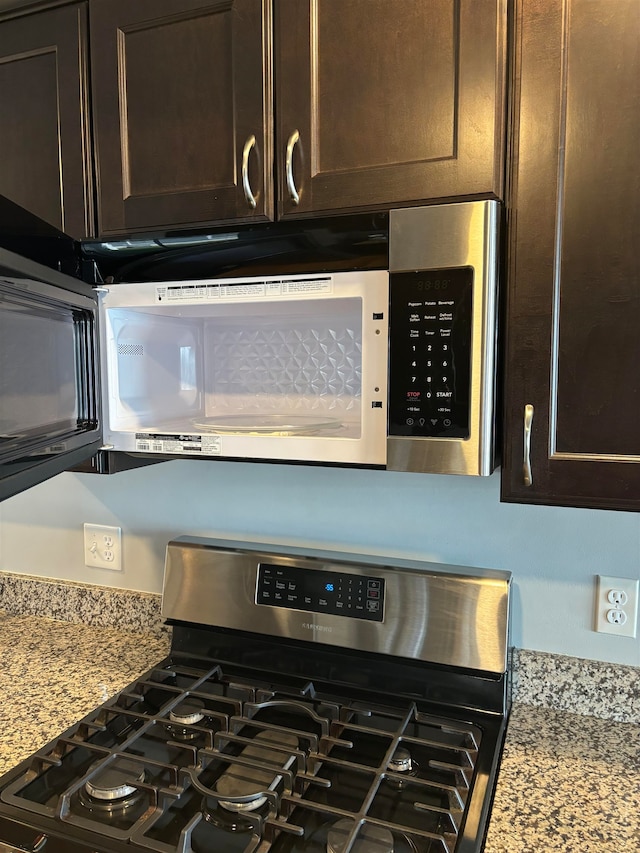 room details featuring light stone countertops, appliances with stainless steel finishes, and dark brown cabinets