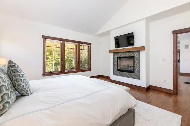 16 Crooked Mountain Rd, Lincoln, NH 03251 - bedroom featuring wood finished floors, lofted ceiling, and a glass covered fireplace