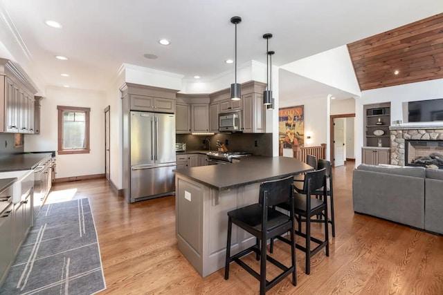 16 Crooked Mountain Rd, Lincoln, NH 03251 - kitchen featuring stainless steel appliances, dark countertops, gray cabinetry, open floor plan, and a kitchen bar