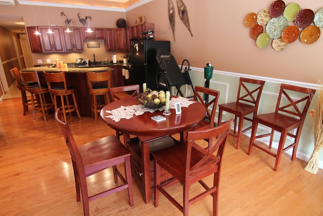 dining area featuring light hardwood / wood-style flooring and crown molding