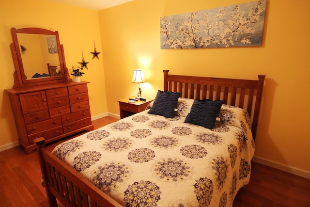 bedroom with dark hardwood / wood-style floors