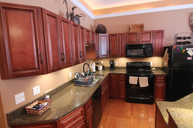 kitchen with ornamental molding, sink, black appliances, dark stone counters, and light hardwood / wood-style floors