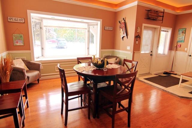 dining area featuring light wood-type flooring and crown molding