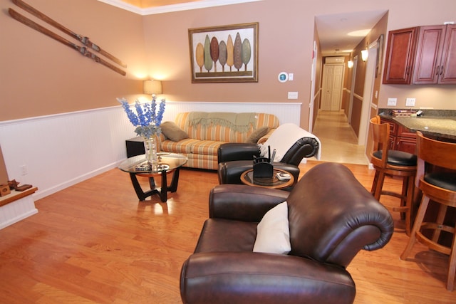 living room with light hardwood / wood-style floors and ornamental molding