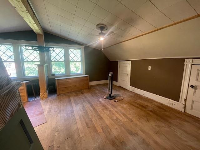 bonus room featuring vaulted ceiling with beams and wood-type flooring