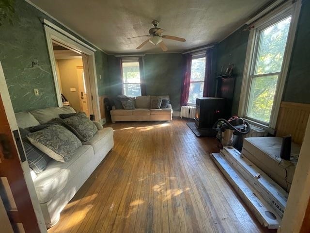 living room with ceiling fan, hardwood / wood-style floors, and radiator heating unit