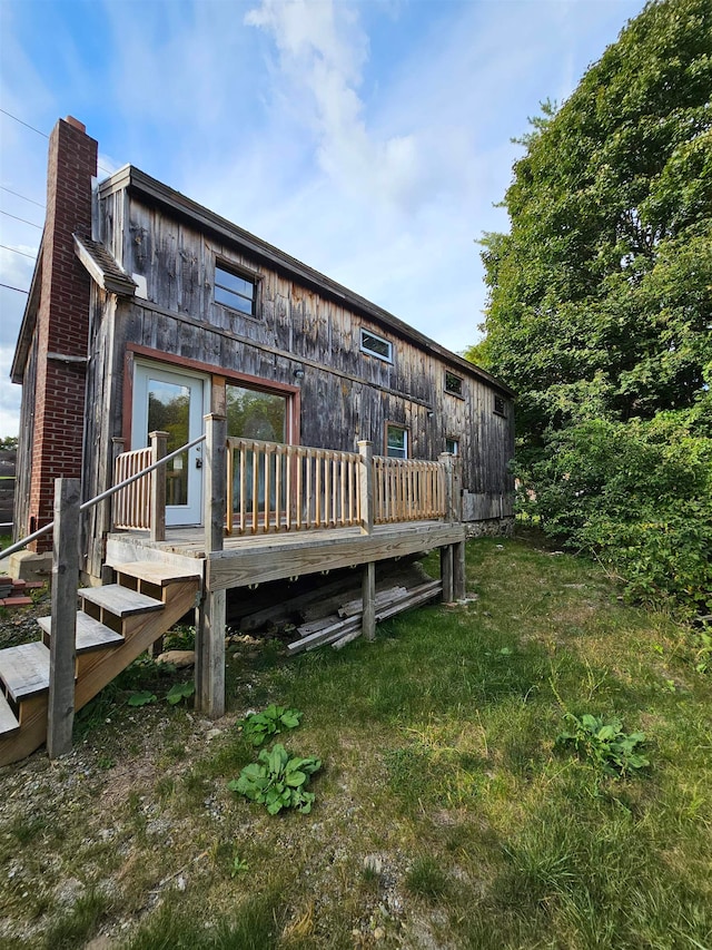 back of house with a deck and a yard