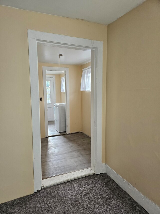 hall featuring wood-type flooring and washer / dryer