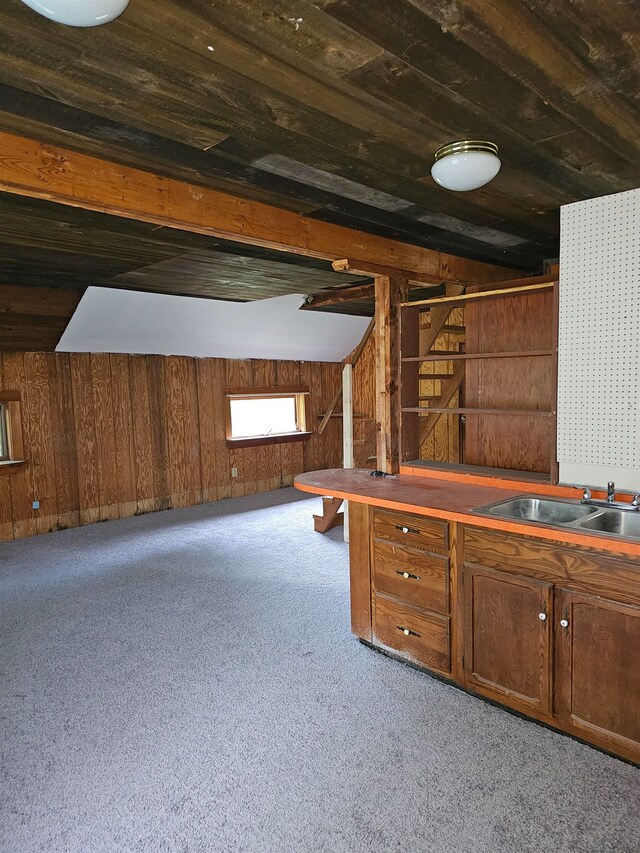 interior space with wood ceiling, wood walls, sink, and light colored carpet