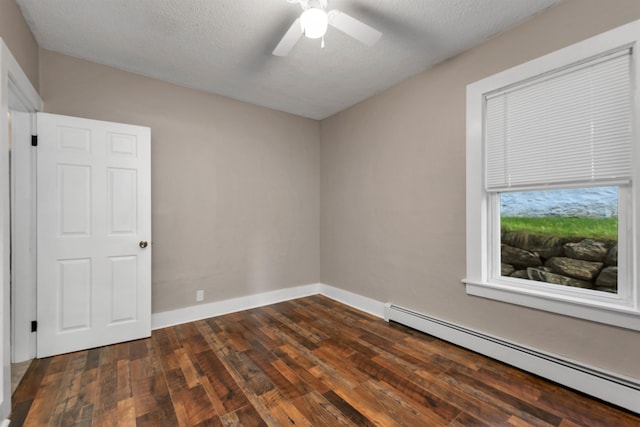 spare room featuring dark hardwood / wood-style floors, a textured ceiling, baseboard heating, and ceiling fan