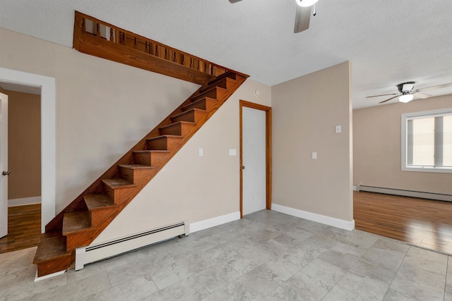 interior space with ceiling fan, a baseboard radiator, and a textured ceiling