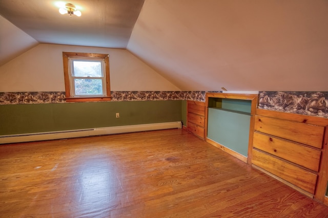 bonus room featuring vaulted ceiling, light wood-style flooring, and a baseboard radiator