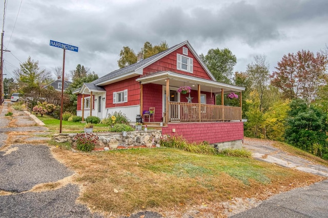 bungalow-style house featuring covered porch and a front lawn