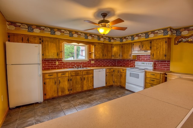 kitchen featuring under cabinet range hood, a sink, white appliances, brown cabinetry, and ceiling fan