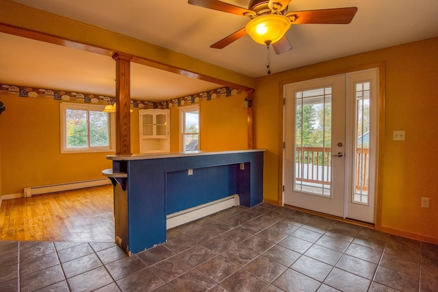 interior space featuring a baseboard radiator, baseboards, a peninsula, and ceiling fan