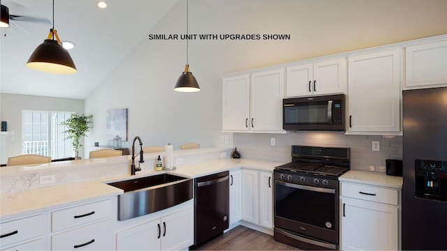 kitchen with black appliances, white cabinetry, hanging light fixtures, and sink