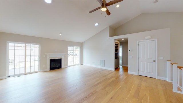 unfurnished living room featuring high vaulted ceiling, ceiling fan, light hardwood / wood-style floors, and a healthy amount of sunlight