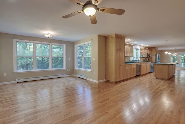 unfurnished living room featuring ceiling fan, sink, light hardwood / wood-style floors, and a baseboard heating unit