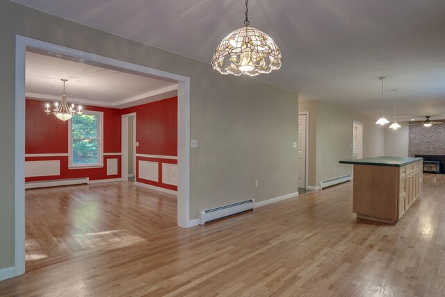 kitchen featuring light wood-type flooring, light brown cabinetry, a fireplace, and baseboard heating