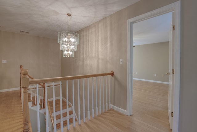 hallway featuring light hardwood / wood-style flooring and a chandelier