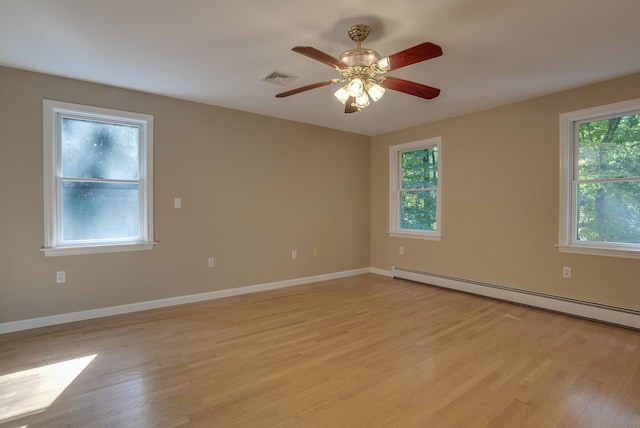 spare room featuring a baseboard radiator, ceiling fan, and light hardwood / wood-style flooring