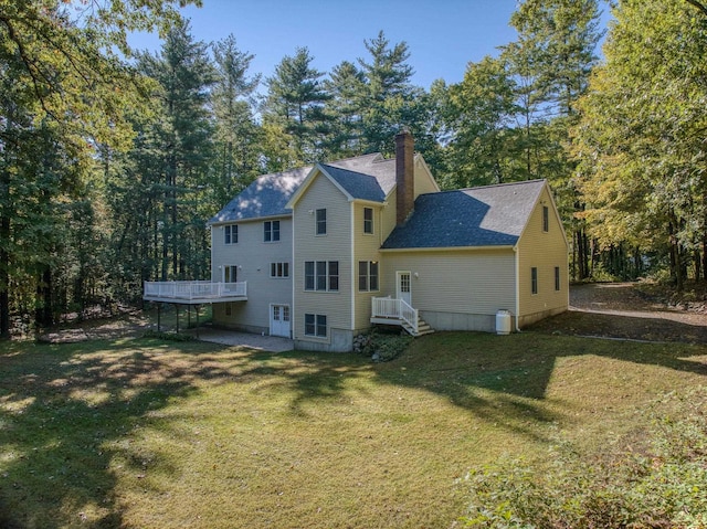 rear view of house featuring a deck and a yard