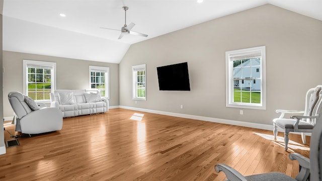 living room with light hardwood / wood-style flooring, vaulted ceiling, and ceiling fan