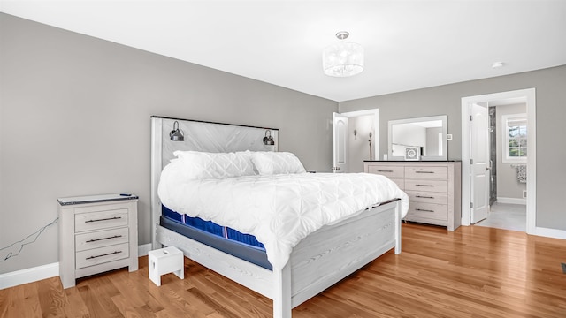 bedroom with light hardwood / wood-style flooring and connected bathroom