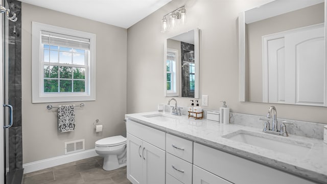 bathroom featuring tile patterned floors, a shower with shower door, vanity, and toilet