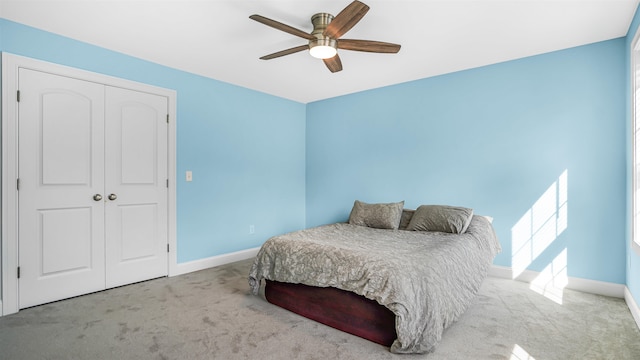 carpeted bedroom featuring ceiling fan and a closet