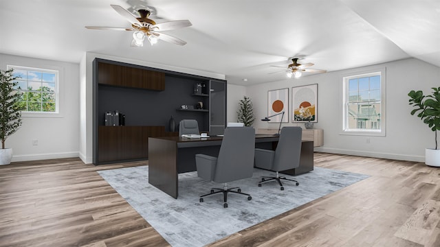 office space featuring light hardwood / wood-style flooring, lofted ceiling, and ceiling fan