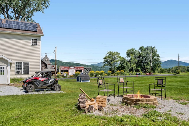 view of yard featuring a fire pit and a mountain view