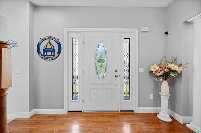 entrance foyer featuring light hardwood / wood-style flooring and decorative columns