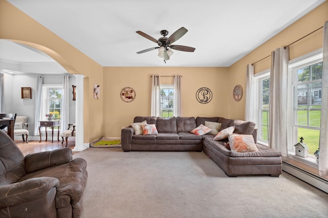 living room with a healthy amount of sunlight, decorative columns, a baseboard heating unit, and ceiling fan