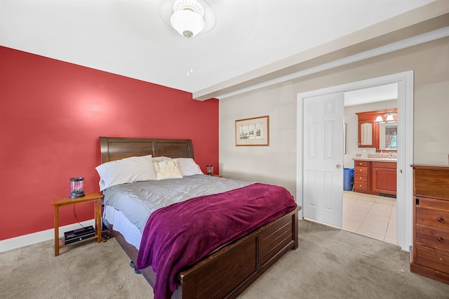 bedroom featuring ensuite bath, sink, and light colored carpet