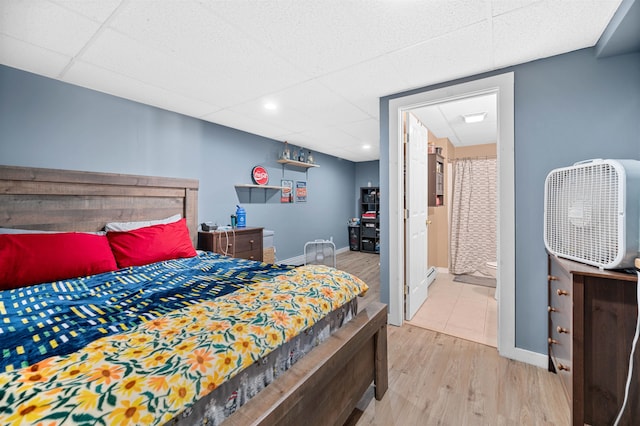 bedroom with light hardwood / wood-style floors and ensuite bathroom