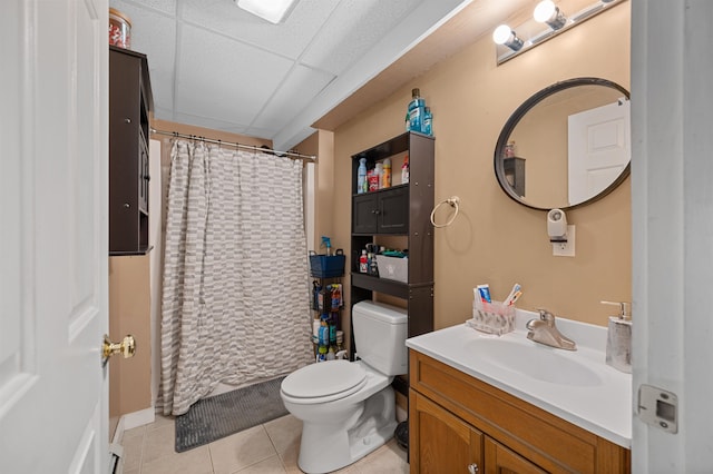 bathroom featuring vanity, walk in shower, a paneled ceiling, toilet, and tile patterned floors