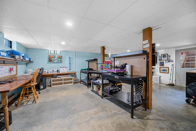 interior space with a drop ceiling and a workshop area