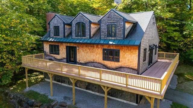 rear view of house featuring a deck and a garage