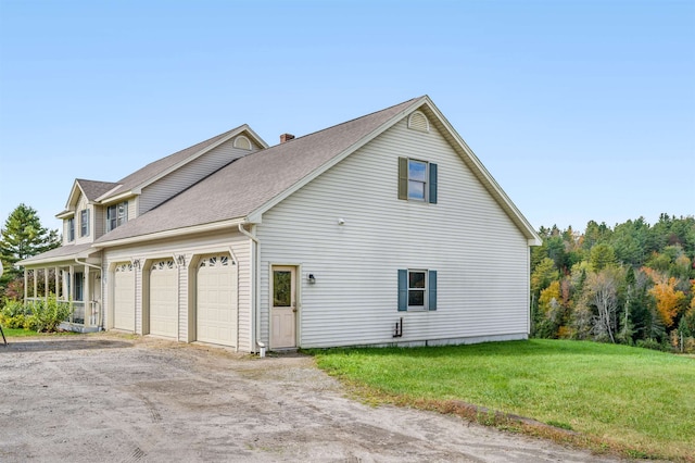 view of side of property with a garage and a lawn