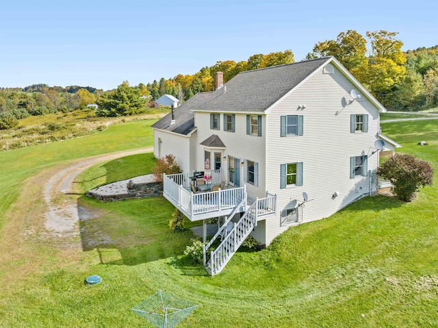 back of house with a deck and a yard