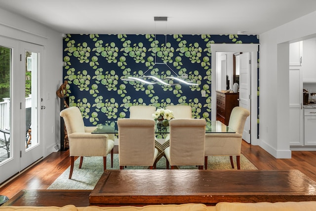 dining space with hardwood / wood-style floors and a healthy amount of sunlight