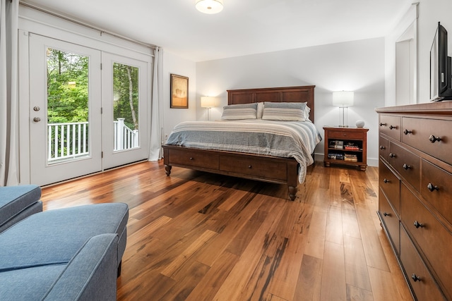 bedroom with hardwood / wood-style floors and access to exterior