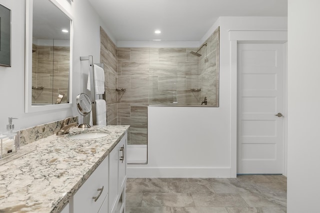 bathroom featuring a tile shower and vanity