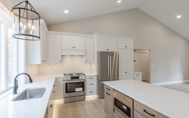 kitchen with sink, decorative light fixtures, stainless steel appliances, and white cabinets