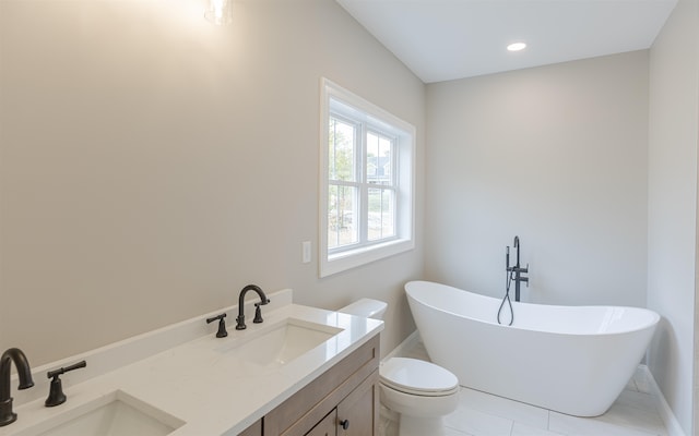 bathroom featuring vanity, tile patterned flooring, a bathtub, and toilet