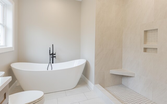 bathroom with tile patterned flooring, a washtub, and toilet