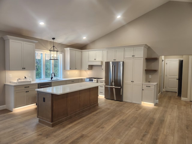 kitchen featuring a kitchen island, white cabinetry, sink, hanging light fixtures, and stainless steel appliances