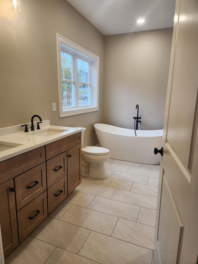 bathroom with vanity, a bathtub, tile patterned floors, and toilet